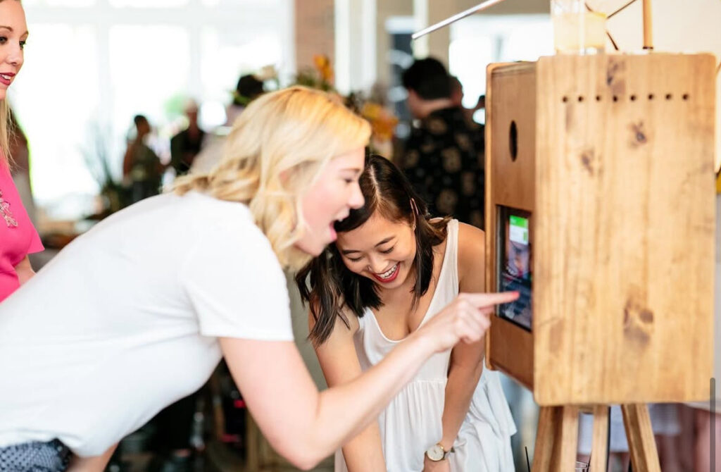 A woman sends a photo to her phone from a Nashville Smile Bar photo booth