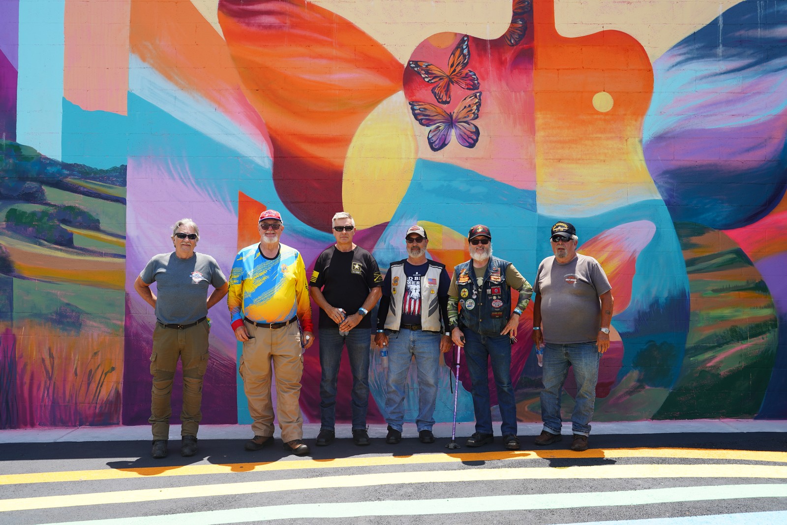 Motorcycle riders posing at the mural